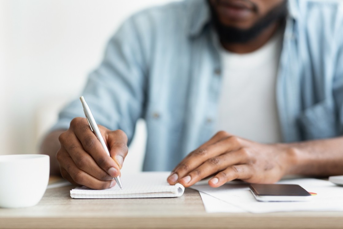 Male writing down on this notepad